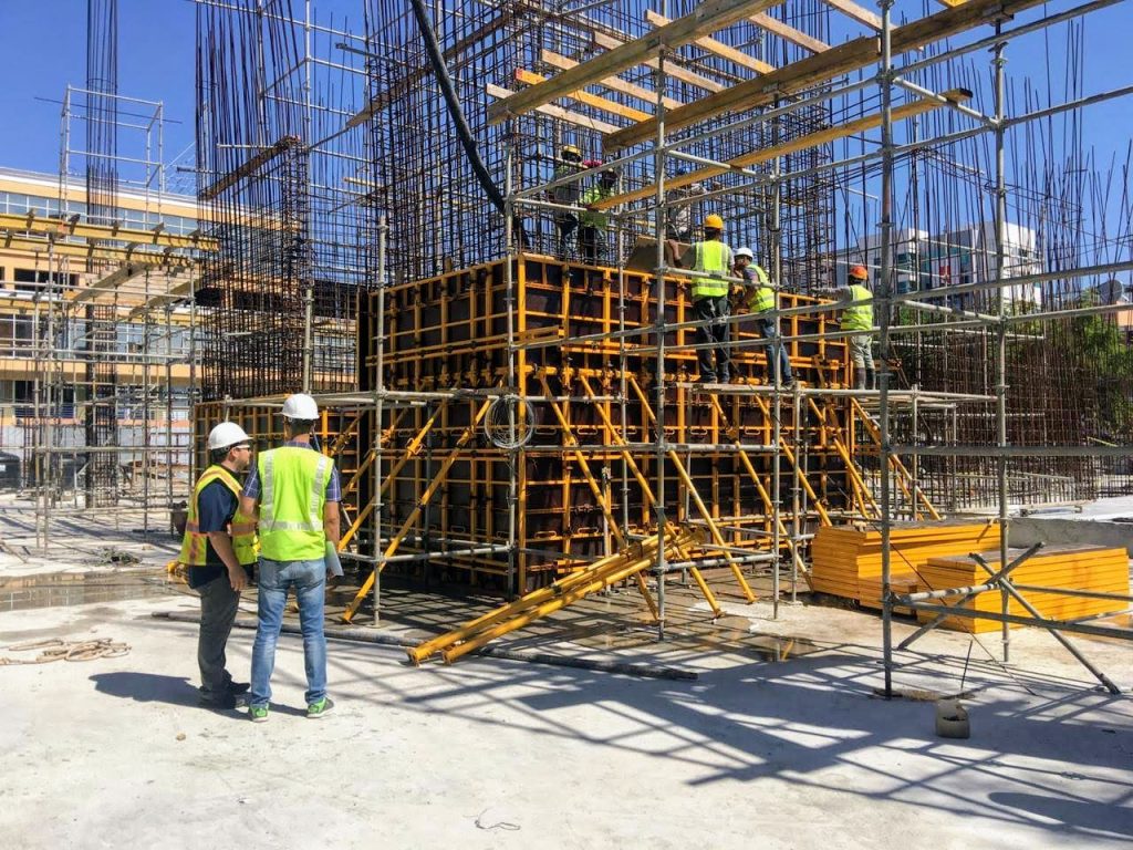 Núcleo de edificio encofrado con formaleta metal madera de gran formato, con trabajadores sobre andamios certificados multidireccionales